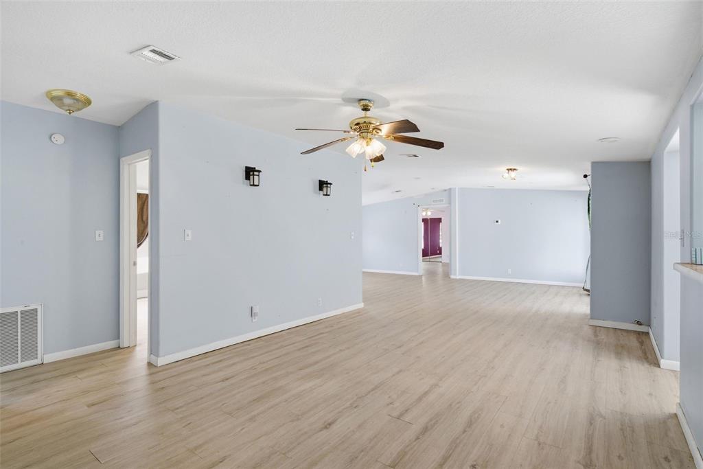 A spacious living area features light blue walls, wood-look flooring, and a ceiling fan — 2295 S STONEBROOK DRIVE, HOMOSASSA, FL