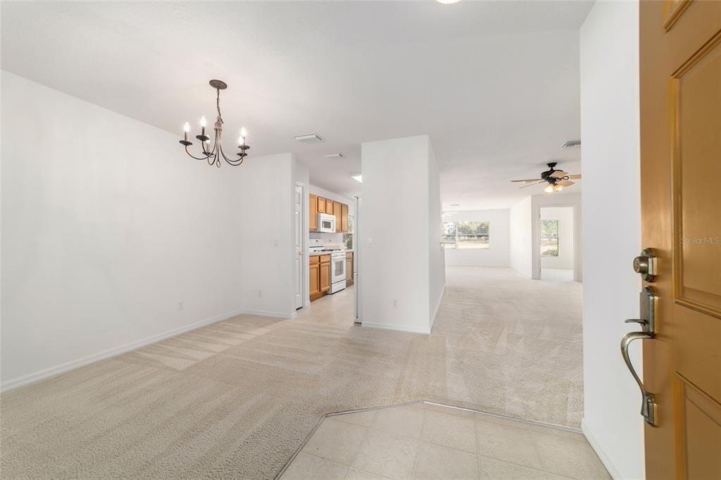 An entryway leads into a carpeted dining area with a chandelier and an adjacent kitchen — 9150 SW 102ND CIRCLE, OCALA, FL