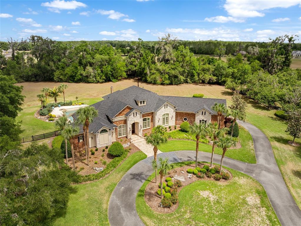 An aerial view shows a large brick and stone house with a circular driveway — 15508 NW 45TH PLACE, NEWBERRY, FL