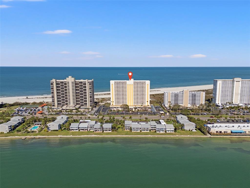 An aerial view shows high-rise beachfront condominiums along a coastline with a red location pin — 1270 GULF BOULEVARD UNIT 1007, CLEARWATER BEACH, FL