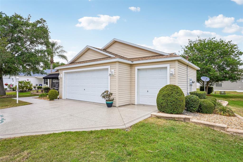 A kitchen features wood cabinets, granite countertops, a central island with bar stools, and appliances — 447 FOSTER PLACE, THE VILLAGES, FL