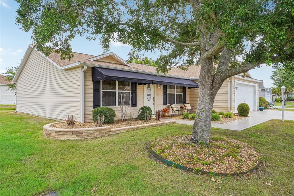 A kitchen features wood cabinets, granite countertops, a center island, and an adjacent dining area — 447 FOSTER PLACE, THE VILLAGES, FL