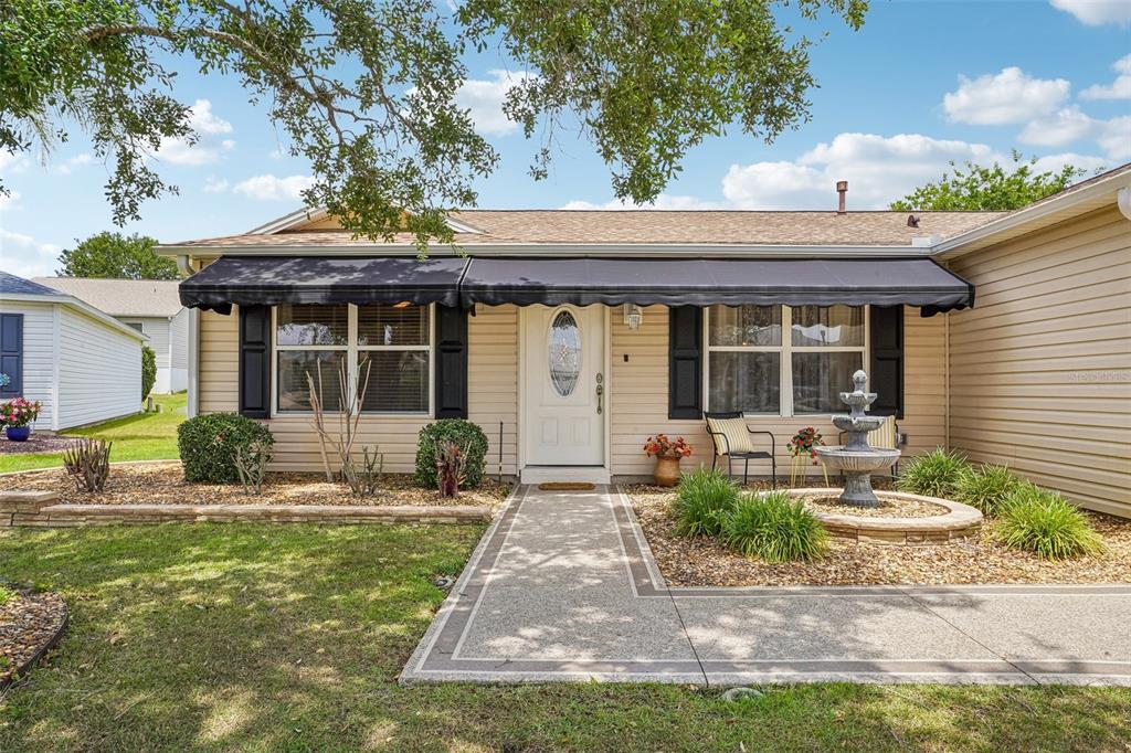 A spacious living and dining area features vaulted ceilings, hardwood flooring, and ceiling fans — 447 FOSTER PLACE, THE VILLAGES, FL