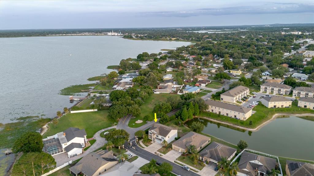 An aerial view shows a suburban neighborhood with a house highlighted by a yellow arrow — 1389 HERITAGE LANDINGS DRIVE, LAKELAND, FL