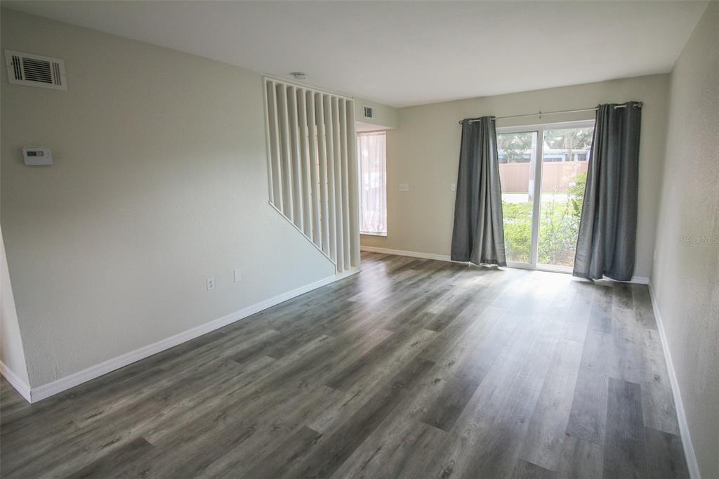 A living room features light gray walls, wood-look flooring, and a sliding glass door — 1836 N CRYSTAL LAKE DRIVE UNIT 68, LAKELAND, FL