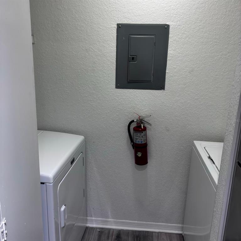 A laundry closet features a wall-mounted electrical panel, a fire extinguisher, and two white appliances — 8939 LATREC AVENUE UNIT 1303, ORLANDO, FL