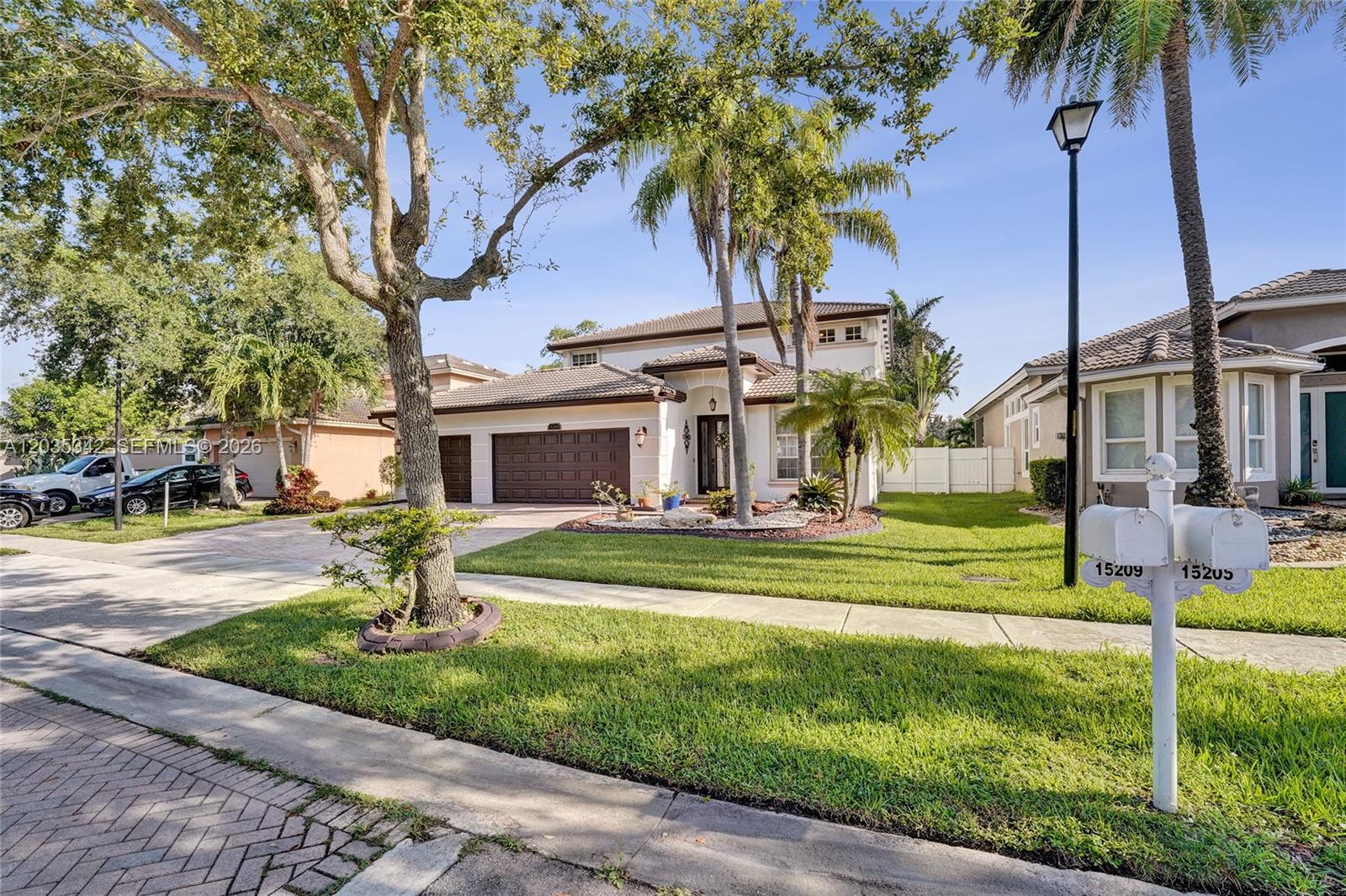 A two-story suburban house with a brown garage and a manicured lawn — MIRAMAR, FL