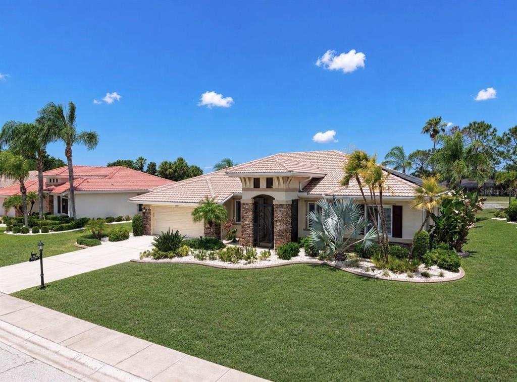 A single-story suburban house with a tile roof, stone facade, and landscaped front yard — 2208 MYRTLE VISTA COURT, SUN CITY CENTER, FL