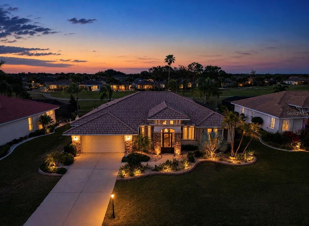 An aerial view of a single-story house with a tile roof at sunset — 2208 MYRTLE VISTA COURT, SUN CITY CENTER, FL