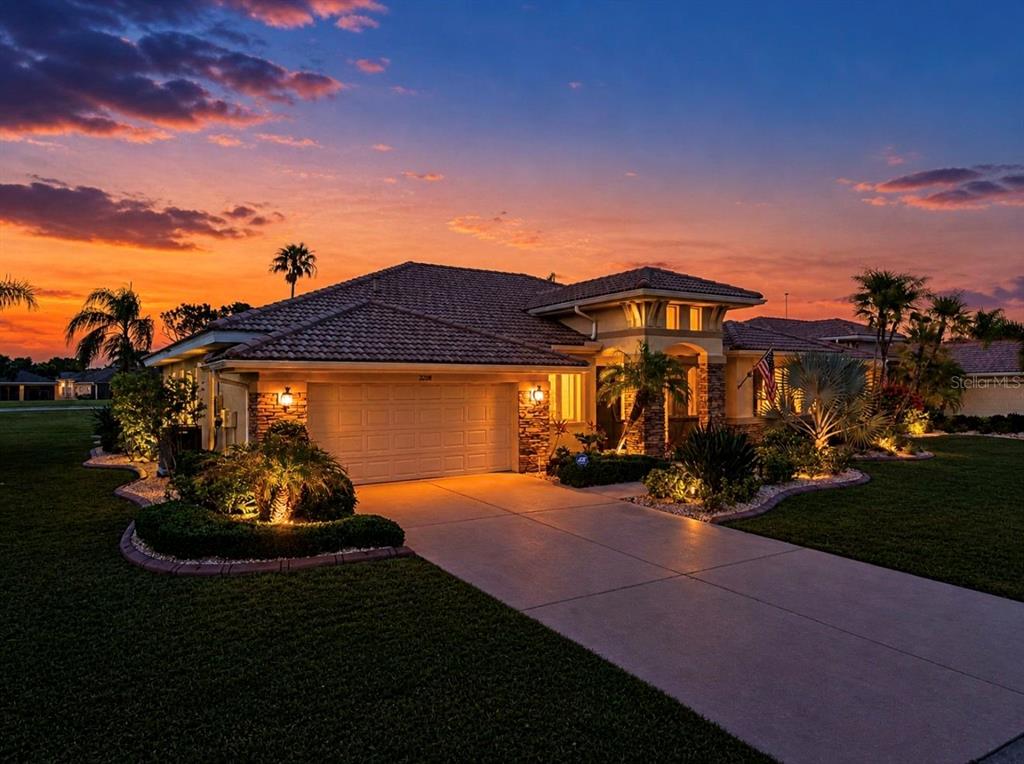 A single-story house with a tiled roof and a garage at sunset — 2208 MYRTLE VISTA COURT, SUN CITY CENTER, FL