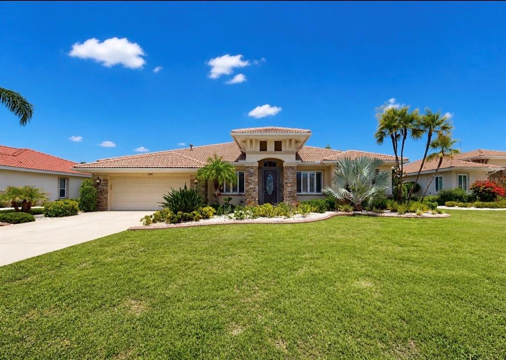 A single-story house with a tile roof, stone accents, and a landscaped front yard — 2208 MYRTLE VISTA COURT, SUN CITY CENTER, FL