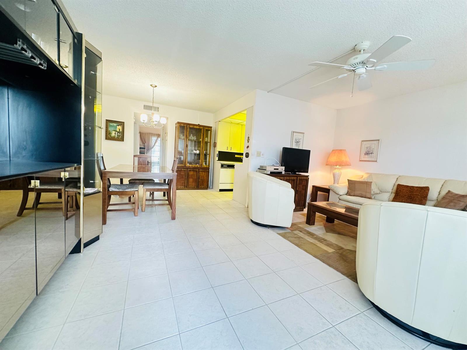 A living room and dining area with white tile floors, a ceiling fan, and furniture — 2060 Harwood E # 2060, Deerfield Beach FL 33442, DEERFIELD BEACH, FL