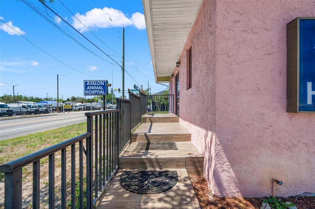 An exterior view of a pink building with a tiled entrance and metal railings — 6603 N FLORIDA AVENUE, TAMPA, FL