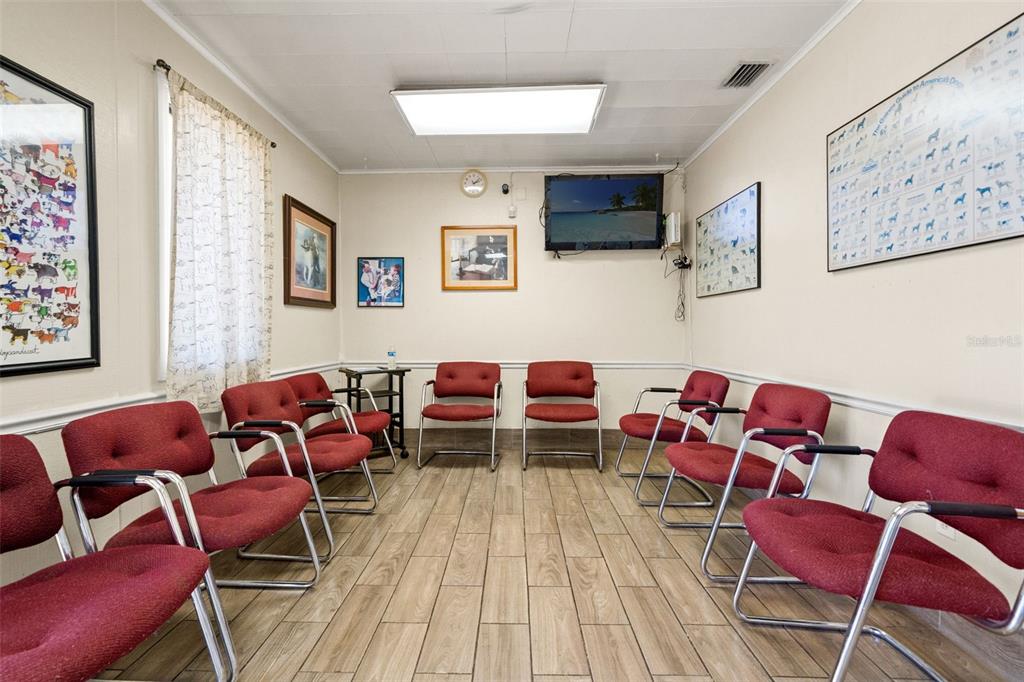 A waiting room features red chairs, wood-look tile flooring, and several framed animal-themed posters — 6603 N FLORIDA AVENUE, TAMPA, FL