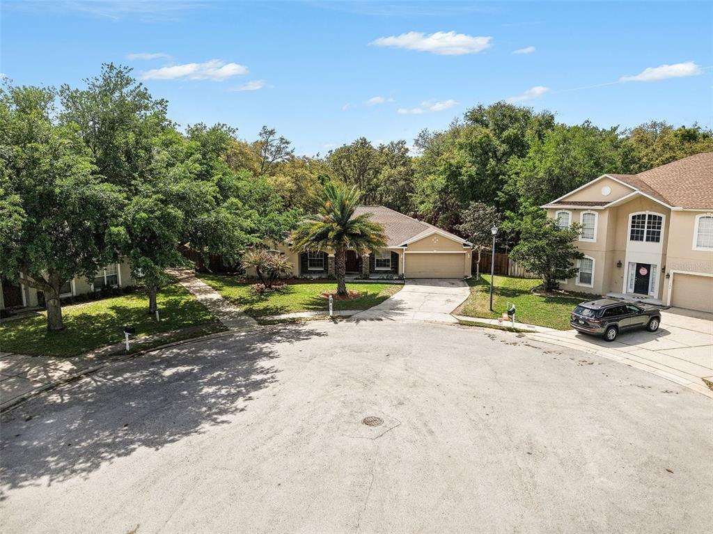 A single-story house with a garage and a palm tree sits at the end of a cul-de-sac — 100 FESTIVE COURT, CHULUOTA, FL