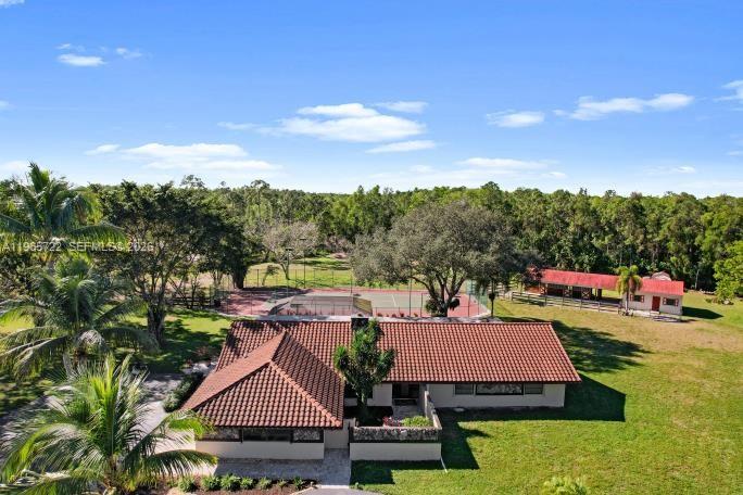 A gated driveway entrance features stone pillars, decorative lamps, and palm trees at dusk — 3761 Dellwood Blvd., Loxahatchee FL 33470, LOXAHATCHEE, FL