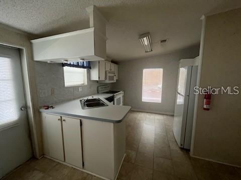 A kitchen with white cabinets, a peninsula sink, and tile flooring — 232 NESBITT PARK AVENUE, DAVENPORT, FL