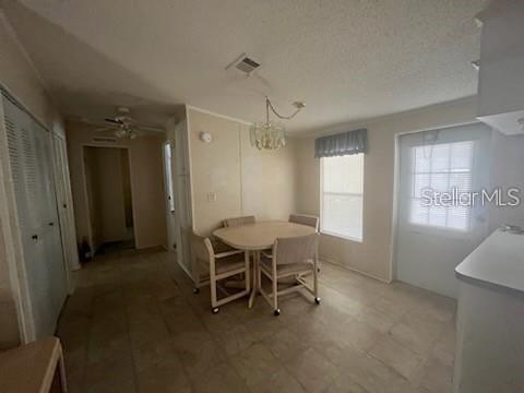 A dining area with a round table, four chairs, tile flooring, and a glass door — 232 NESBITT PARK AVENUE, DAVENPORT, FL