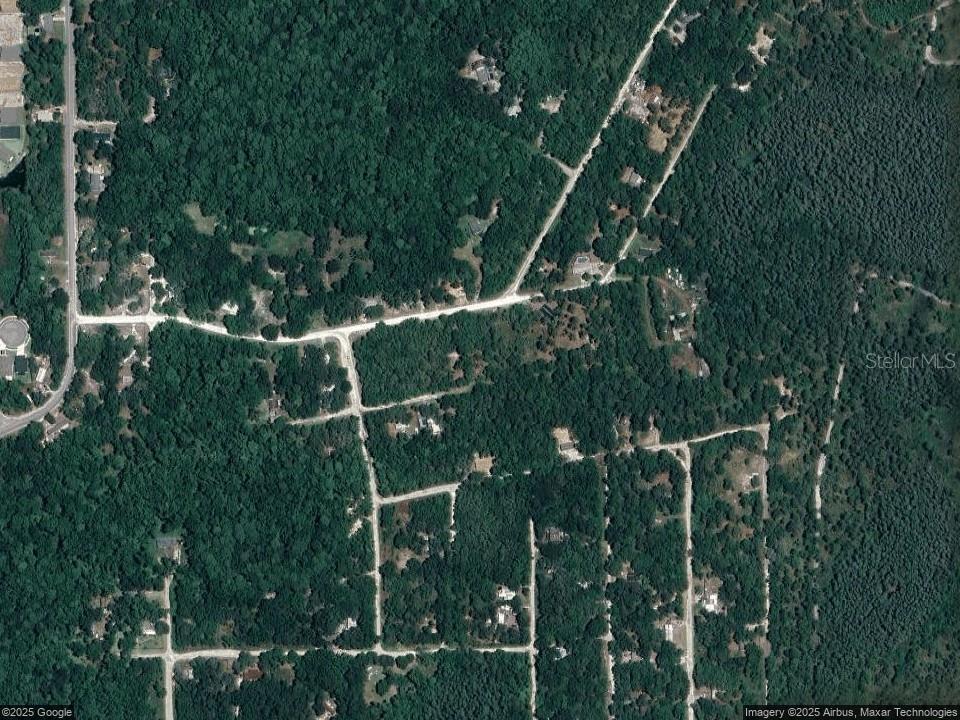 An aerial satellite view shows a wooded residential area with several houses and dirt roads — 13027 DUCHESS AVENUE, NEW PORT RICHEY, FL