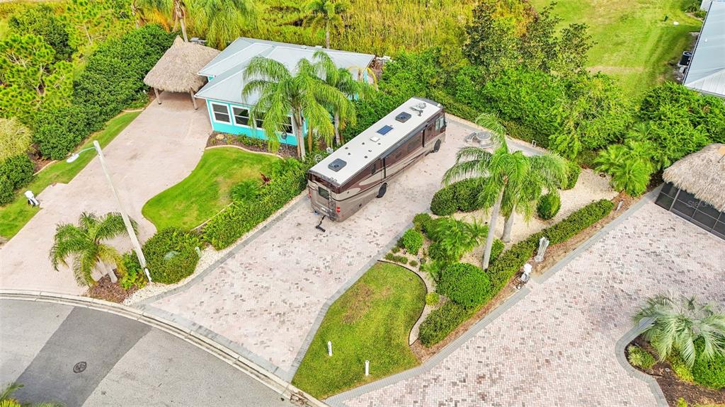 An aerial view shows a house with a tiki hut and a parked recreational vehicle — 3166 GREAT HERON LOOP, POLK CITY, FL
