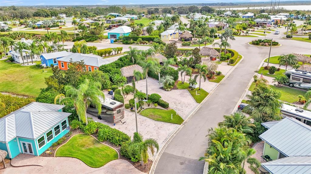 An aerial view shows a residential community with houses, palm trees, and parked recreational vehicles — 3166 GREAT HERON LOOP, POLK CITY, FL