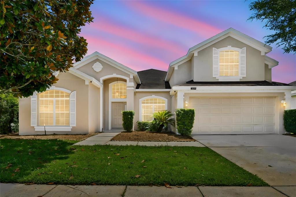 A single-story house with a beige stucco exterior, a two-car garage, and a front lawn — 2337 TREYMORE DRIVE, ORLANDO, FL