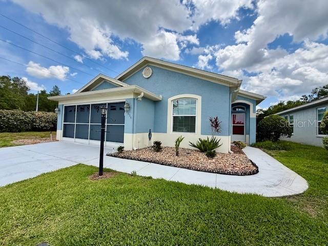The entrance to Timber Greens features a brick sign, tall pine trees, and a gate — 10036 BROOKDALE DRIVE, NEW PORT RICHEY, FL