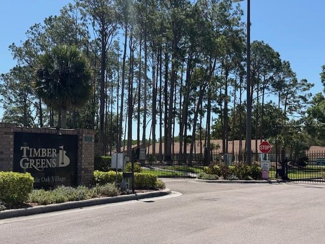An aerial view shows a community clubhouse with a swimming pool and tennis courts — 10036 BROOKDALE DRIVE, NEW PORT RICHEY, FL