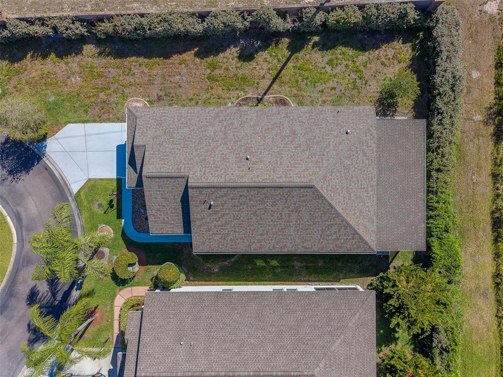 A light blue single-story house features a two-car garage and a landscaped front garden bed — 10036 BROOKDALE DRIVE, NEW PORT RICHEY, FL