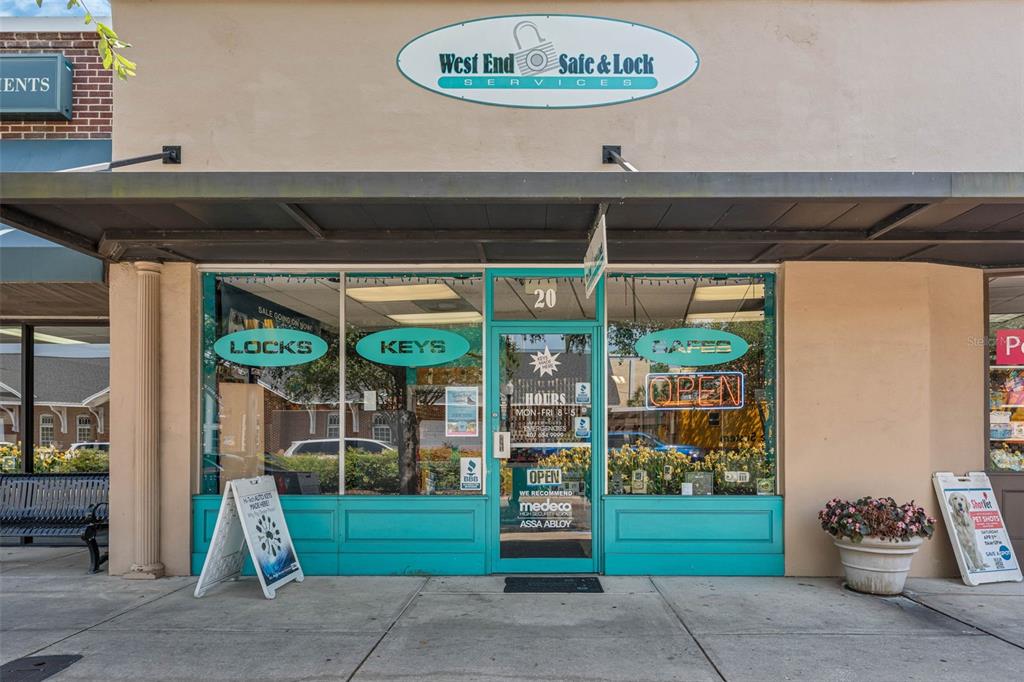 The exterior of a storefront features a teal-trimmed entrance with signage for a locksmith business — 18 & 20 E PLANT STREET, WINTER GARDEN, FL