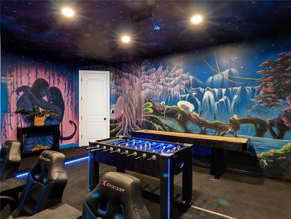 A game room features a foosball table, shuffleboard table, gaming chairs, and Avatar-themed wall murals — 7816 LOXAHATCHEE COURT, REUNION, FL