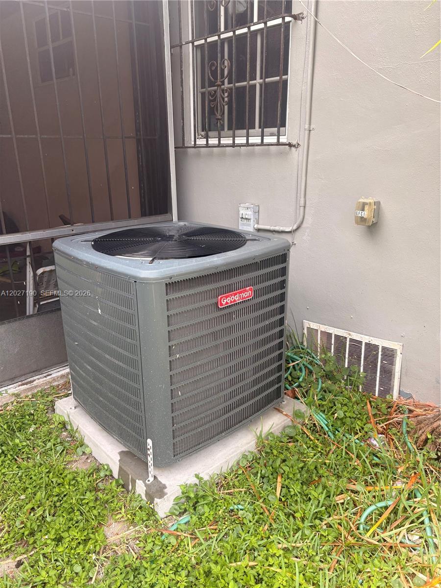 A Goodman air conditioning unit sits on a concrete pad outside a residential building — 1100 NW 110th St, Miami FL 33168, MIAMI, FL