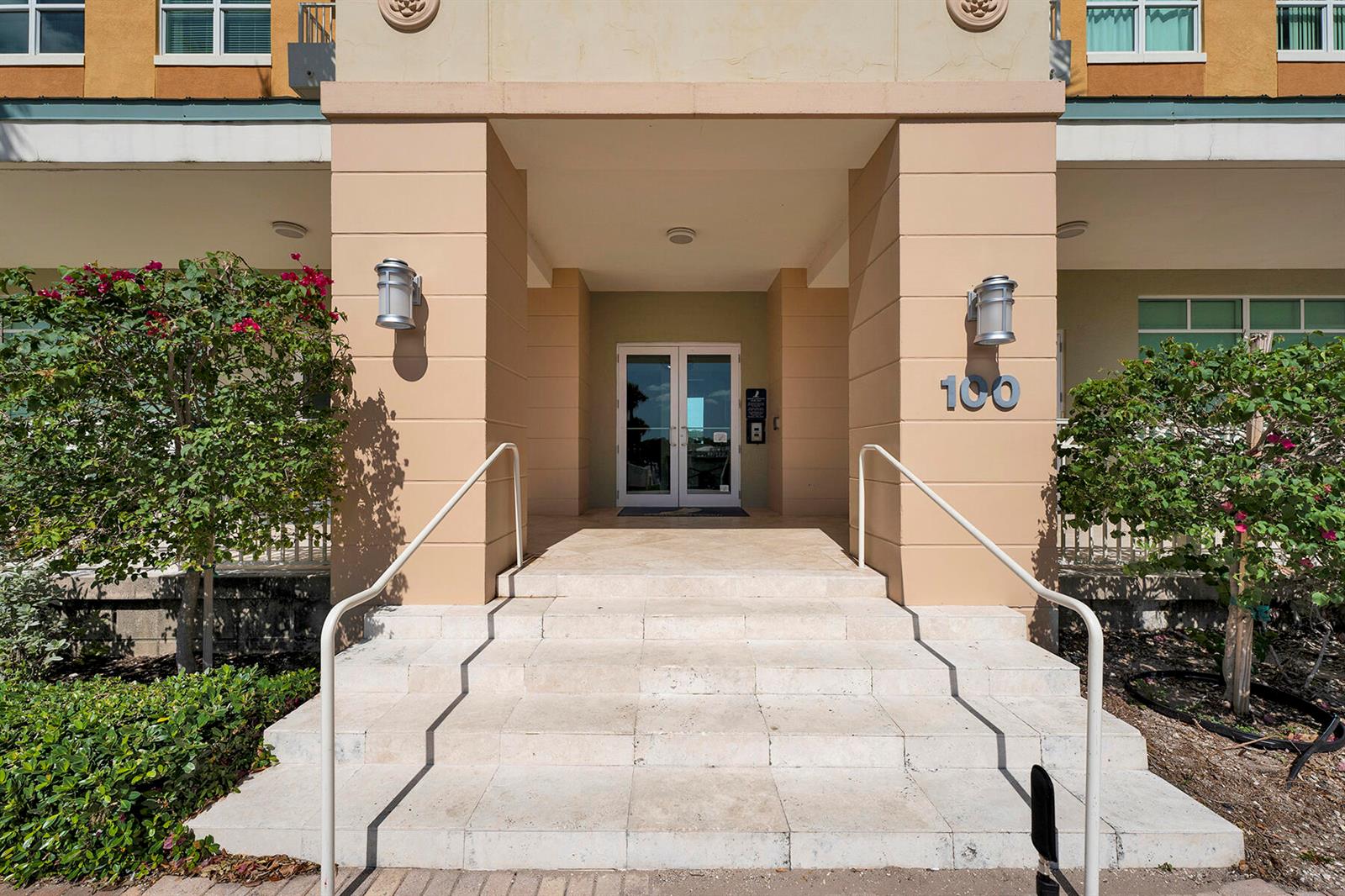 The exterior entrance features a set of stone steps leading to double glass doors — 100 NE 6th Street # 203, Boynton Beach FL 33435, BOYNTON BEACH, FL