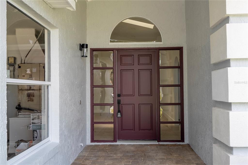 A front entryway features a dark red door with sidelights and a semi-circular transom window — 2218 NEWT STREET, ORLANDO, FL