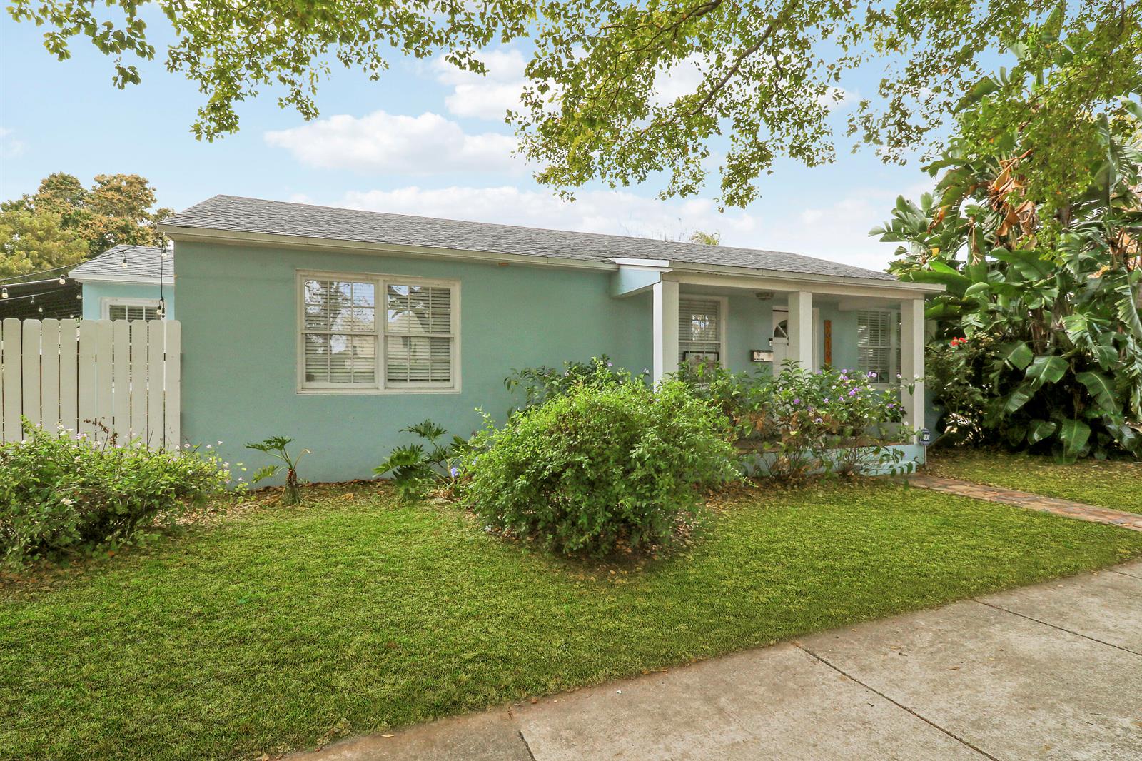 A light blue, single-story house with a front porch and a green lawn — 3619 Spruce Avenue, West Palm Beach FL 33407, WEST PALM BEACH, FL