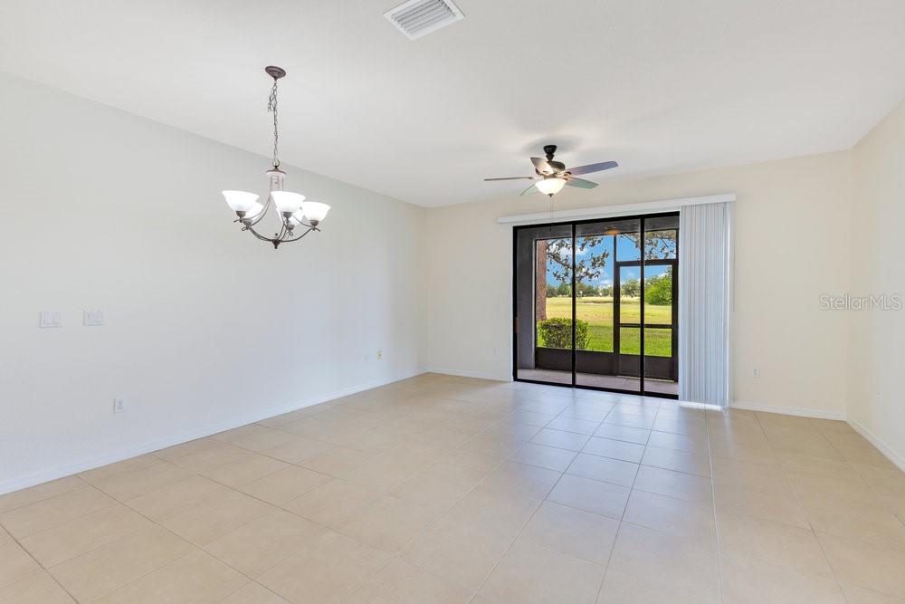 An empty dining area features tile flooring, a chandelier, and sliding glass doors to a lanai — 20610 MAXIM PARKWAY, ORLANDO, FL