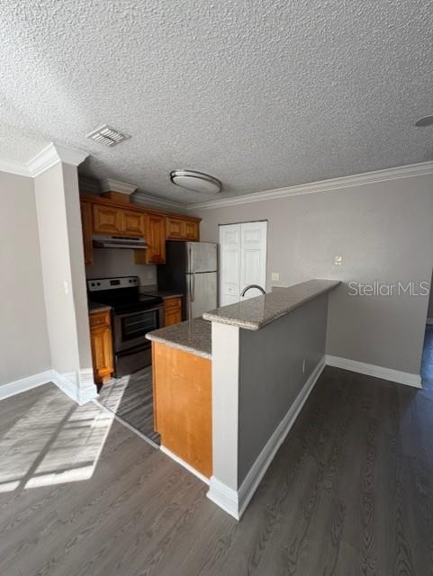 A kitchen features wood cabinets, stainless steel appliances, and a granite-topped breakfast bar — 7298 ULMERTON RD UNIT 611, LARGO, FL