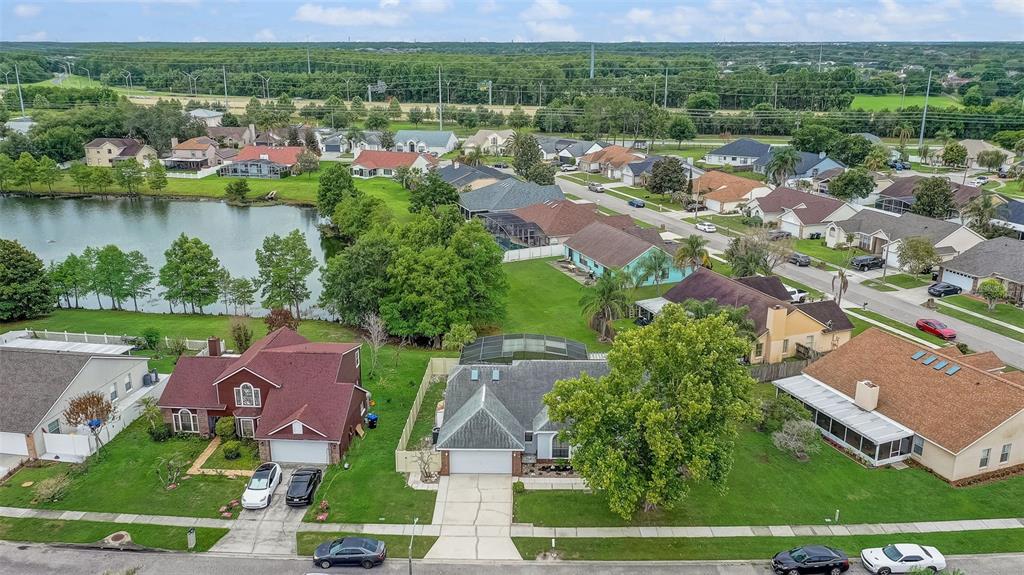 An aerial view shows suburban houses with pools and lawns near a small lake — 2358 OLDFIELD DRIVE, ORLANDO, FL