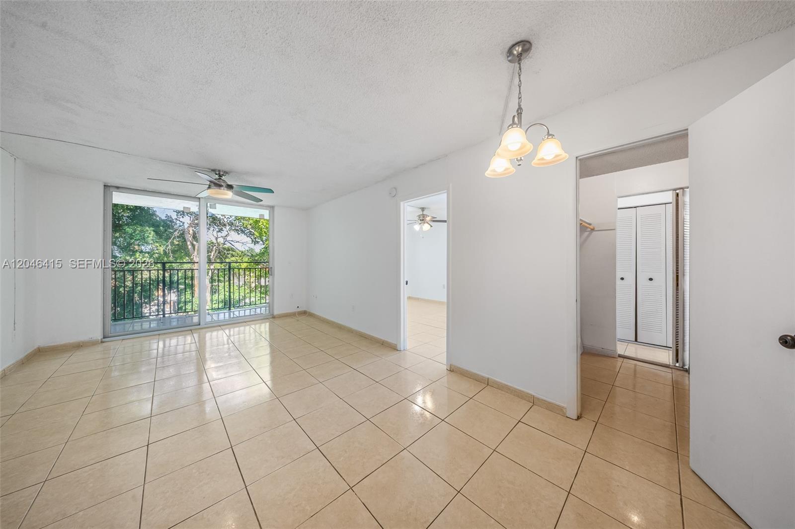 An empty room with beige tile flooring, a ceiling fan, and a sliding glass balcony door — 14155 SW 87th St, Miami FL 33183, MIAMI, FL