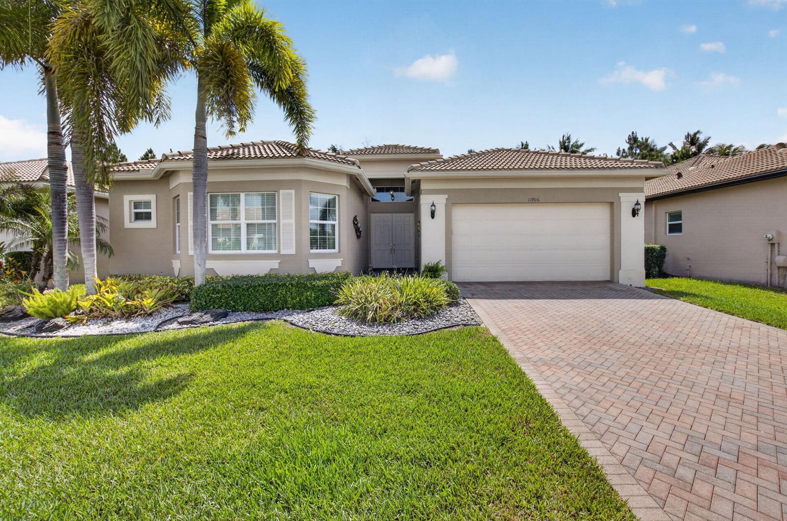 A single-story house with a beige stucco exterior, a tile roof, and a paved driveway — 11906 Catskill Commons Lane, Boynton Beach FL 33473, BOYNTON BEACH, FL