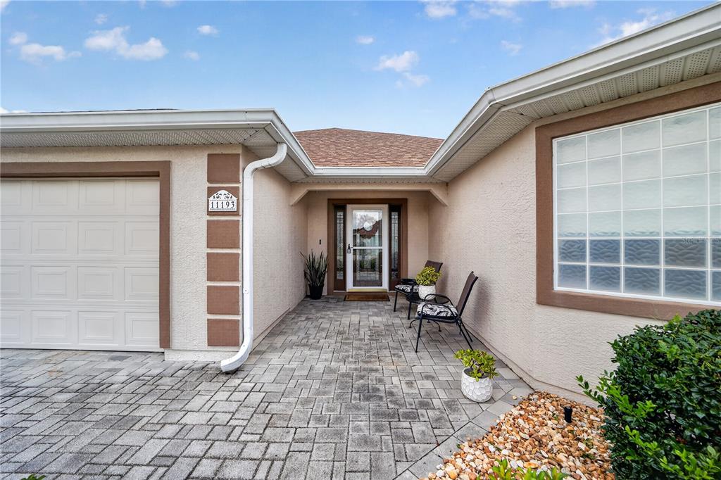 A paved driveway leads to a front entrance with a garage and a glass door — 11193 SE 173RD PLACE, SUMMERFIELD, FL