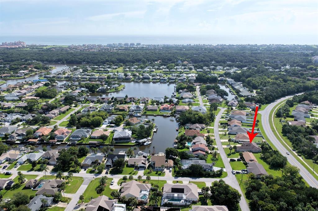 An aerial view shows a residential neighborhood with a red arrow pointing to a house — 40 COLLINGWOOD LANE, PALM COAST, FL