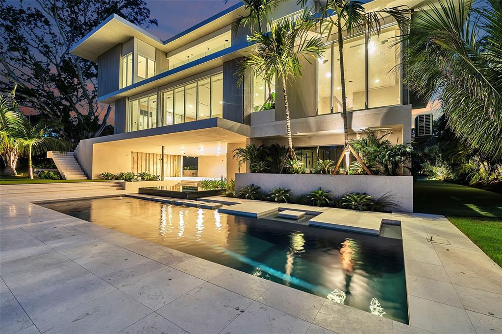 A modern two-story house with a swimming pool, stone patio, and large glass windows — 500 HARBOR COVE CIRCLE, LONGBOAT KEY, FL