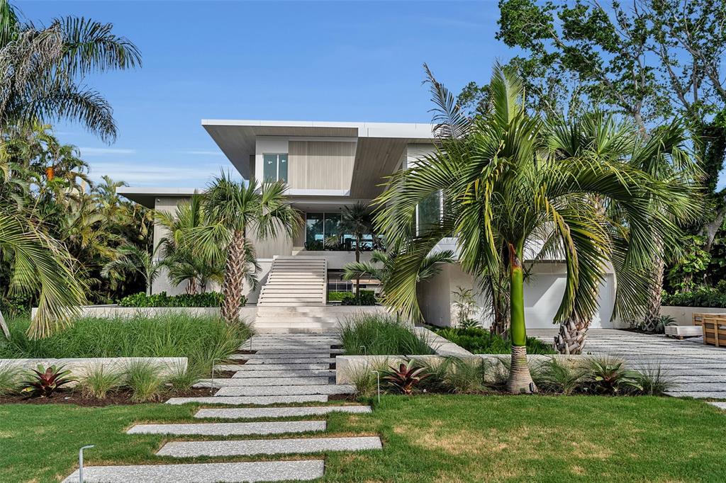 A modern house with a wide staircase and stone walkway surrounded by palm trees — 500 HARBOR COVE CIRCLE, LONGBOAT KEY, FL