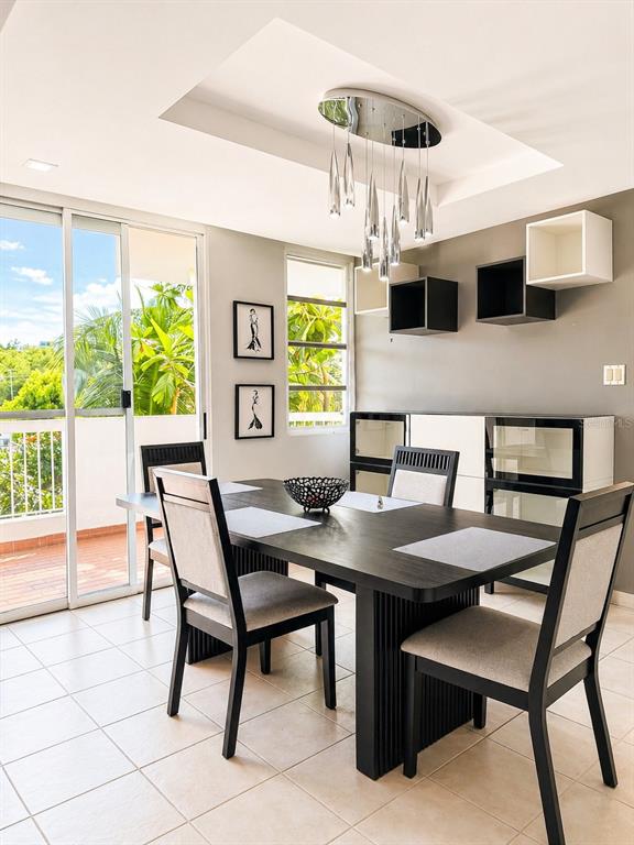 A dining room features a dark wood table, modern chairs, and a unique pendant light — Ave. San Ignacio PRADOS DEL MONTE, GUAYNABO, PR