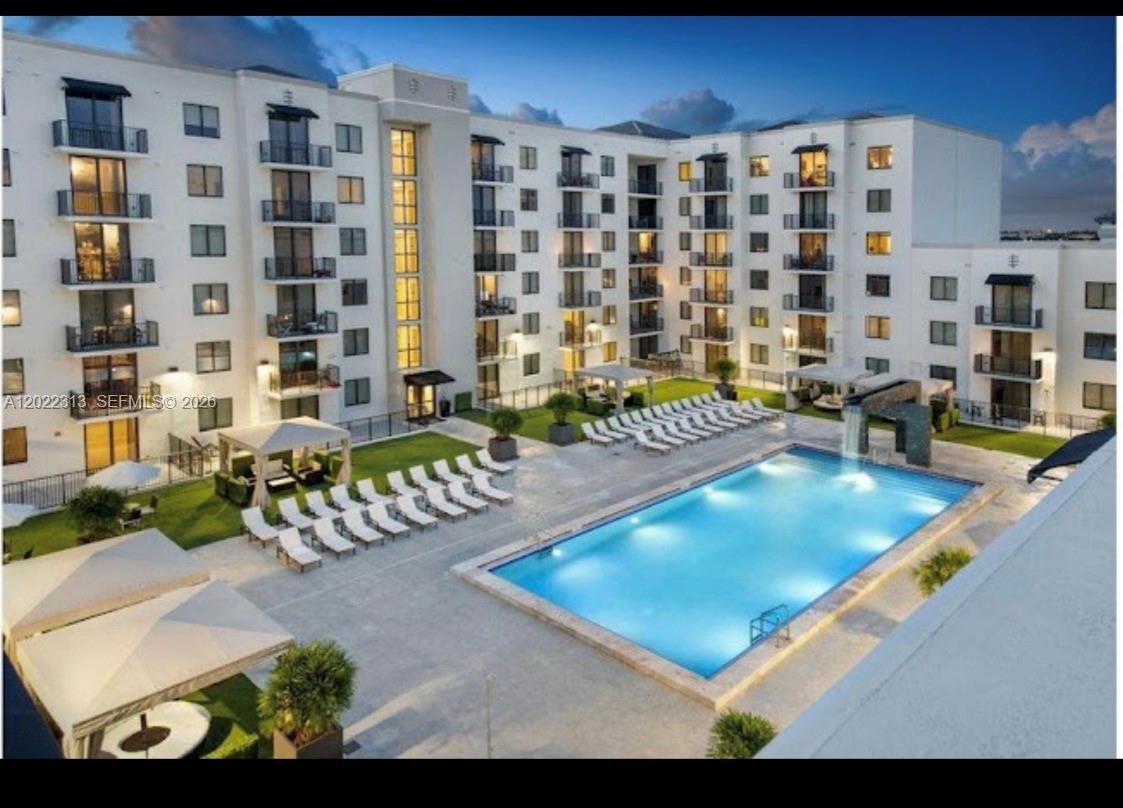 An elevated view of a multi-story apartment building courtyard featuring a swimming pool and lounge — 2001 NW 67th St # 414, West Miami FL 33147, WEST MIAMI, FL