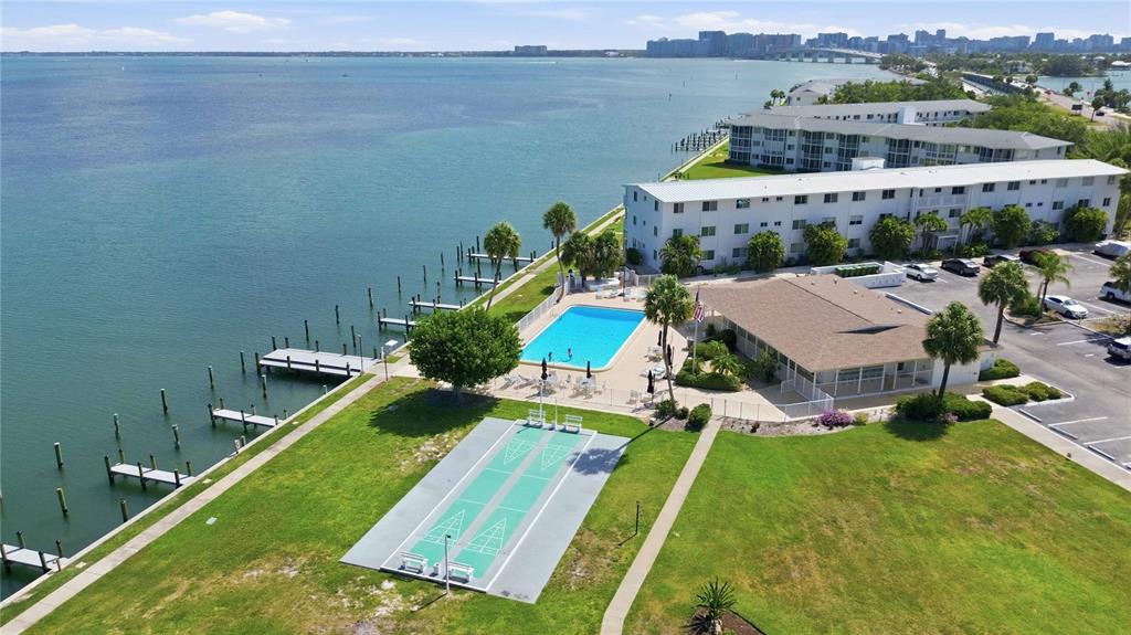 An aerial view of a waterfront apartment complex featuring a swimming pool and shuffleboard courts — 765 JOHN RINGLING BOULEVARD UNIT 1CLARI, SARASOTA, FL