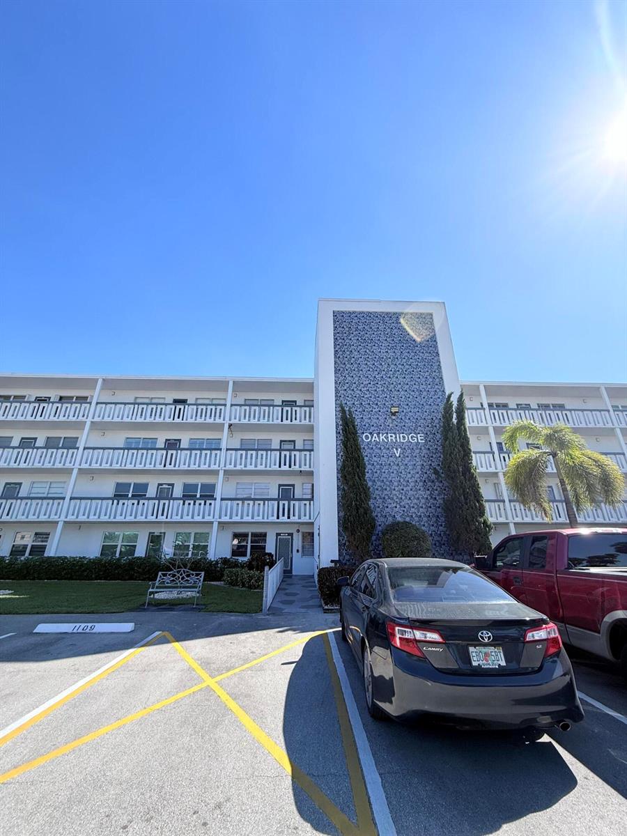 A multi-story apartment building with a blue patterned facade and a parking lot — 4108 Oakridge V # 4108, Deerfield Beach FL 33442, DEERFIELD BEACH, FL