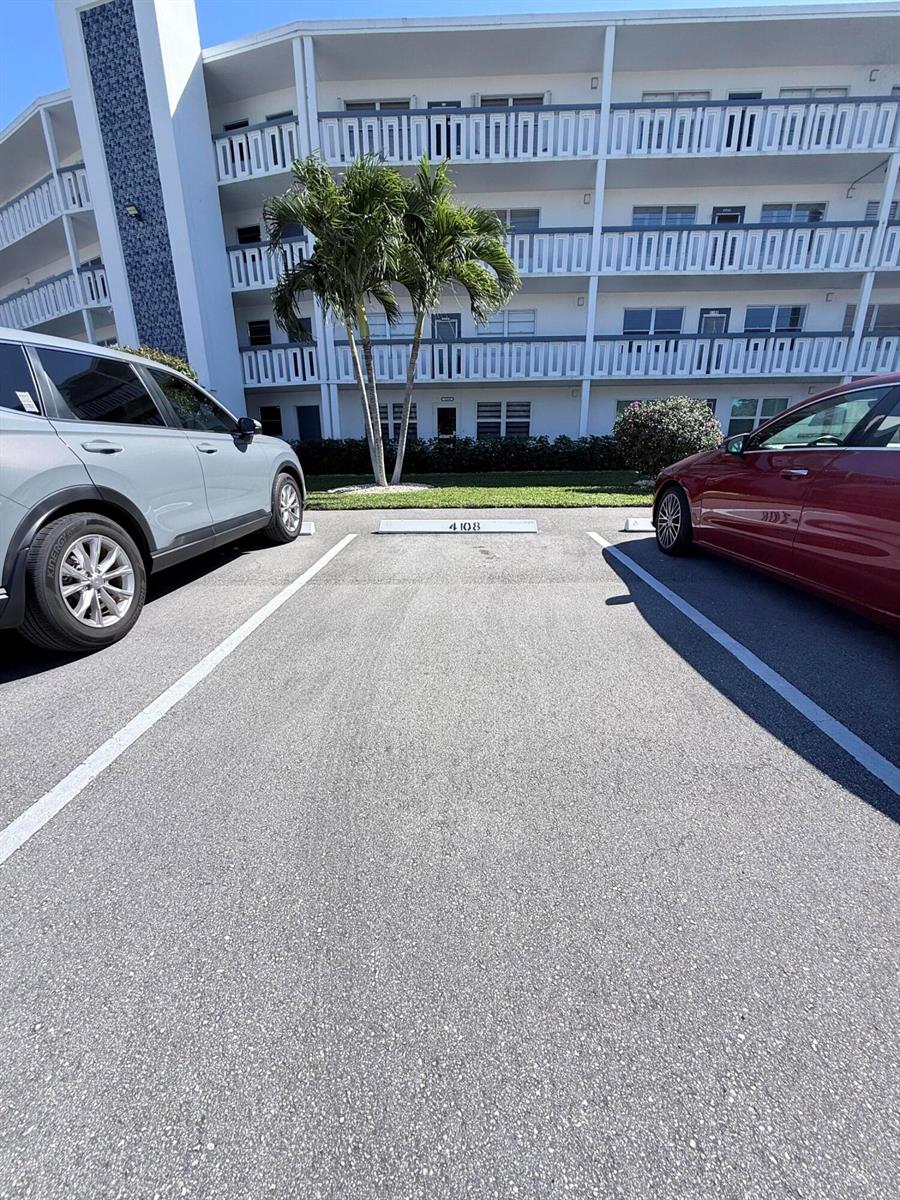 A parking space marked 4108 is situated between two cars in front of an apartment building — 4108 Oakridge V # 4108, Deerfield Beach FL 33442, DEERFIELD BEACH, FL