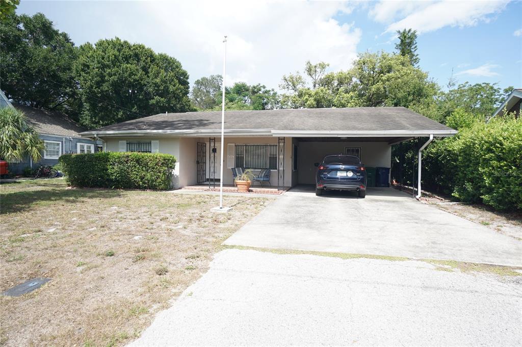 A single-story house with a carport, a concrete driveway, and a front yard with hedges — 207 N GOMEZ AVENUE, TAMPA, FL